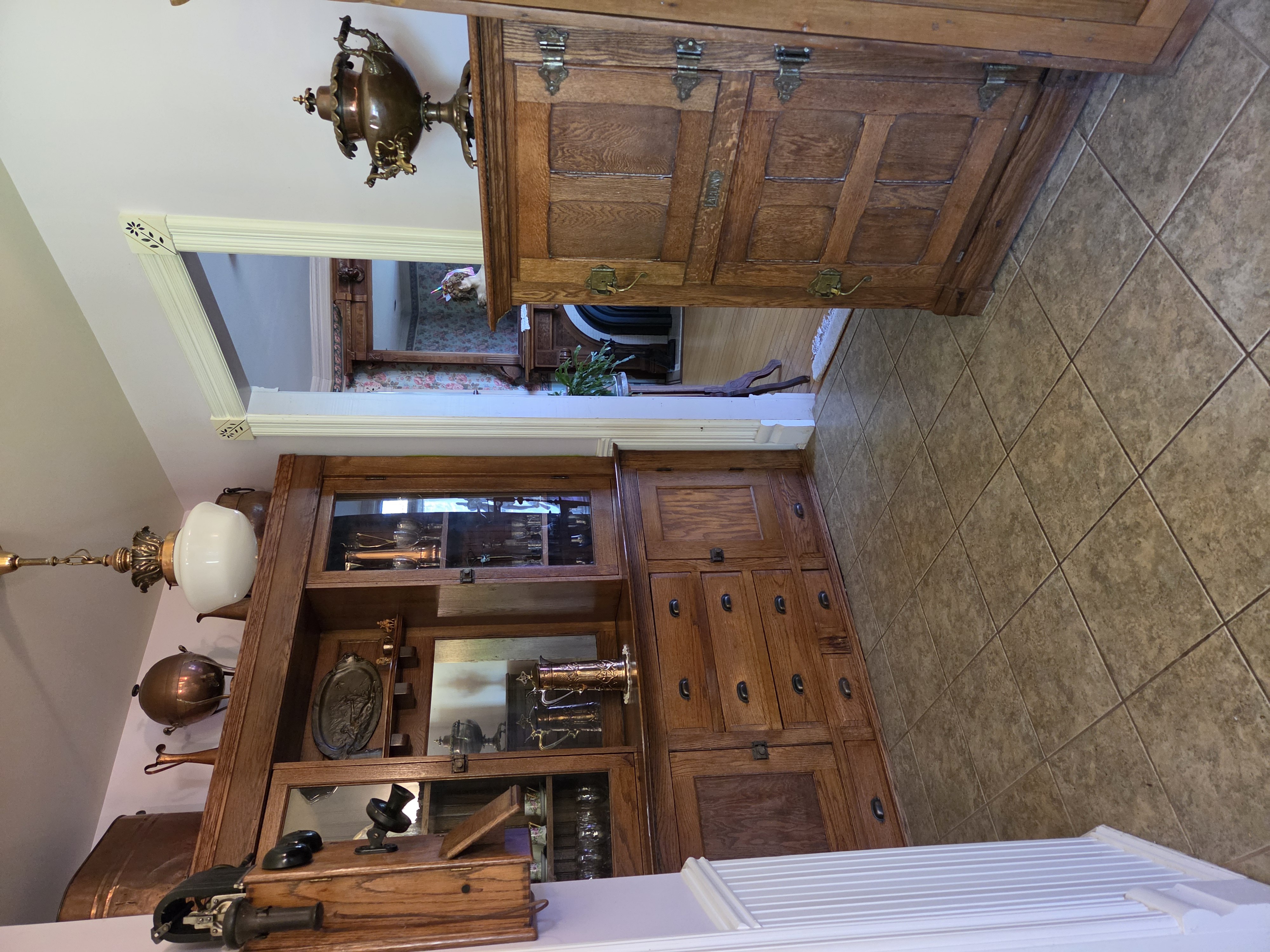 Built-in hardwood hutch with glass display cabinets, brass-pull drawers, and pocket doorway