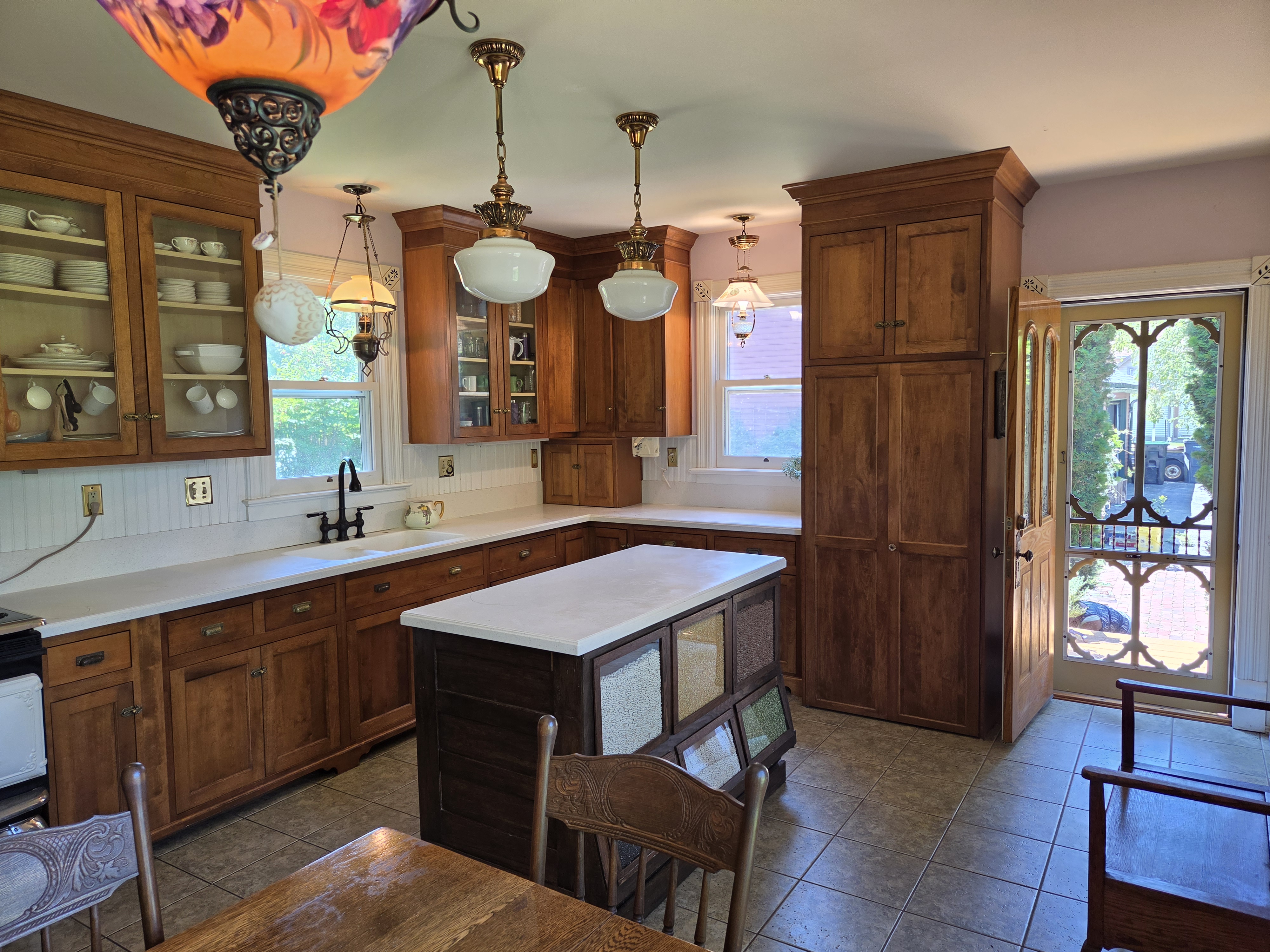 Kitchen with custom hardwood cabinetry, center island, and schoolhouse pendant lights