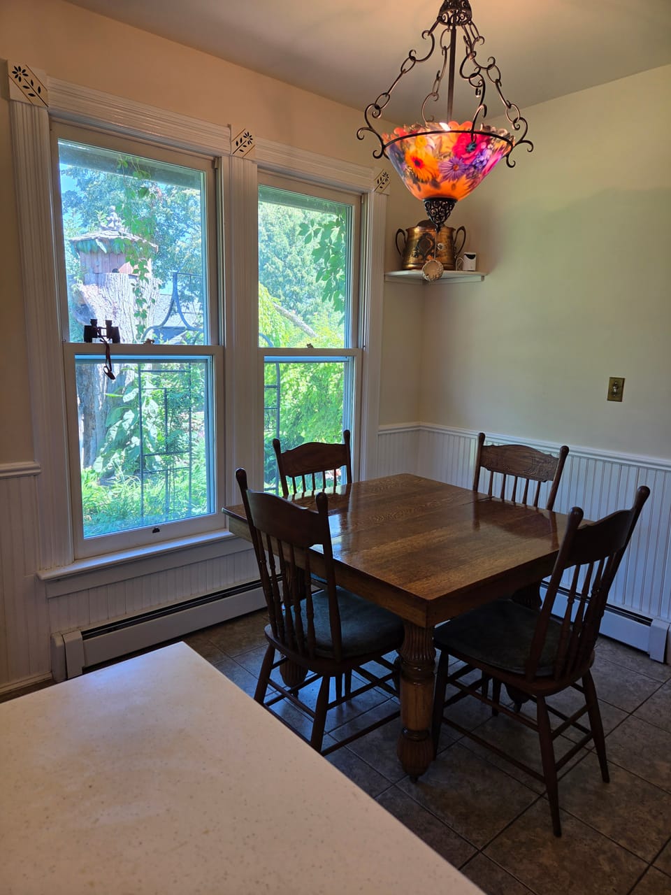 Breakfast nook with stained glass chandelier and garden views